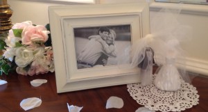 Paper doilies, fake (recyclable) rose petals, and framed pictures of the couple make easy decorations.